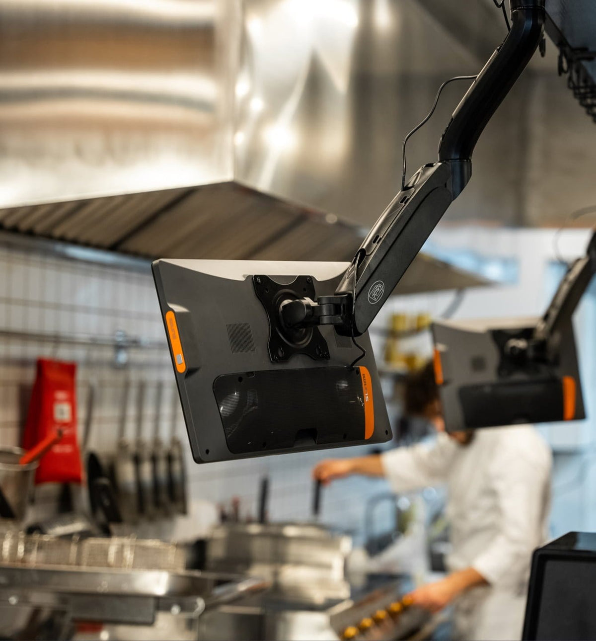 Mounted SUNMI D2s KDS with orange accents in food service setting