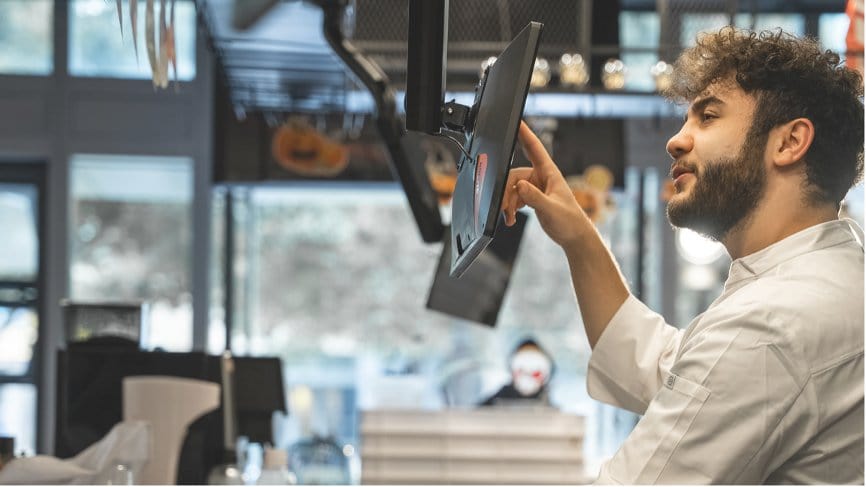 Chef using SUNMI D2s KDS in busy restaurant kitchen