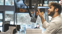 Chef using SUNMI D2s KDS in busy restaurant kitchen