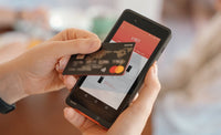 Person using SUNMI P2 Lite SE mobile POS with credit card for contactless payment
